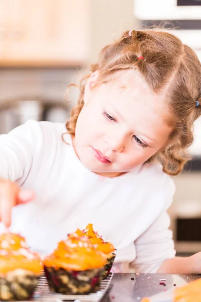 Little Girl Decorating Orange Icing Cupcakes Sprinkle Mix Stock Picture