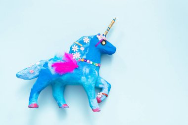 Çocuklar el sanatları. Mavi ve mücevher ve tüyler kağıt mache unicorn ile dekore edilmiş boyalı.