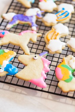 Çocuklar el sanatları. Royal Icing tek boynuzlu at çerezler üzerinde raf kurutma ile dekore edilmiş.