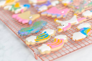 Tek boynuzlu at raf kurutma üzerinde Kraliyet buzlanma ile çocuklar tarafından dekore edilmiş şekerli kurabiye şeklinde.