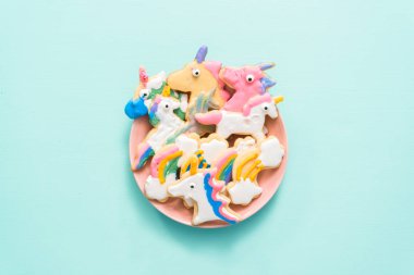 Pembe plaka üzerine Kraliyet krema ile çocuklar tarafından dekore edilmiş şekerli kurabiye şeklinde unicorn.
