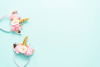 Tek boynuzlu at kafa bandı çiçek ve mavi zemin üzerine altın boynuz.