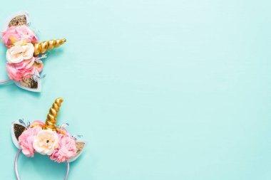 Tek boynuzlu at kafa bandı çiçek ve mavi zemin üzerine altın boynuz.