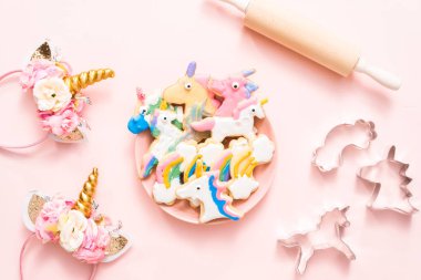 Pembe plaka üzerine Kraliyet krema ile çocuklar tarafından dekore edilmiş şekerli kurabiye şeklinde unicorn.