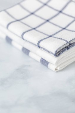 Mermer tezgahın üzerine katlanmış basit mavi desenli yeni mutfak havluları.