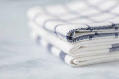 Mermer tezgahın üzerine katlanmış basit mavi desenli yeni mutfak havluları.