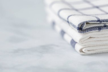 Mermer tezgahın üzerine katlanmış basit mavi desenli yeni mutfak havluları.