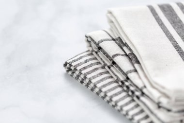 Mermer tezgahın üzerine katlanmış basit siyah desenli yeni mutfak havluları.