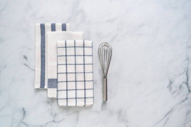 Mermer tezgahın üzerine katlanmış basit mavi desenli yeni mutfak havluları.