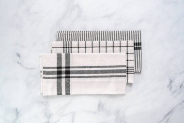 Mermer tezgahın üzerine katlanmış basit siyah desenli yeni mutfak havluları.