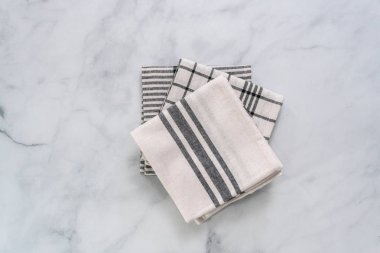 Mermer tezgahın üzerine katlanmış basit siyah desenli yeni mutfak havluları.