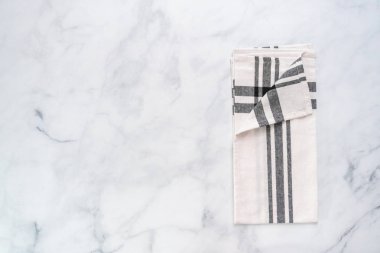 Mermer tezgahın üzerine katlanmış basit siyah desenli yeni mutfak havluları.