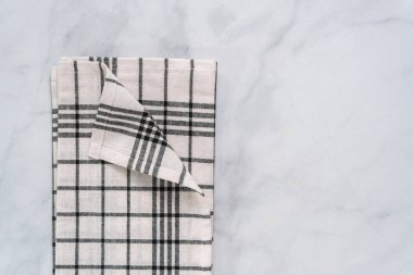 Mermer tezgahın üzerine katlanmış basit siyah desenli yeni mutfak havluları.