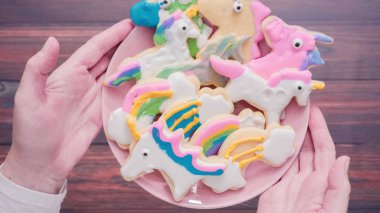 Pembe plaka üzerine Kraliyet krema şeker kurabiye şeklinde unicorn süslenmiş.