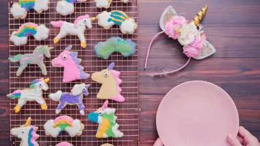Pembe plaka üzerine Kraliyet krema şeker kurabiye şeklinde unicorn süslenmiş.