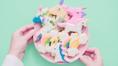 Pembe plaka üzerine Kraliyet krema şeker kurabiye şeklinde unicorn süslenmiş.