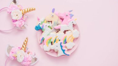 Pembe plaka üzerine Kraliyet krema şeker kurabiye şeklinde unicorn süslenmiş.