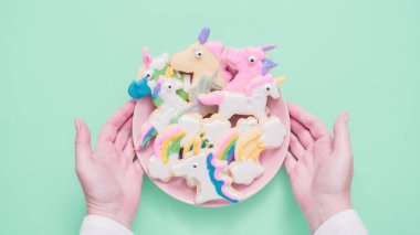 Pembe plaka üzerine Kraliyet krema şeker kurabiye şeklinde unicorn süslenmiş.