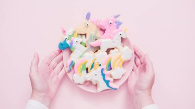 Pembe plaka üzerine Kraliyet krema şeker kurabiye şeklinde unicorn süslenmiş.