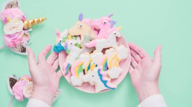 Pembe plaka üzerine Kraliyet krema şeker kurabiye şeklinde unicorn süslenmiş.