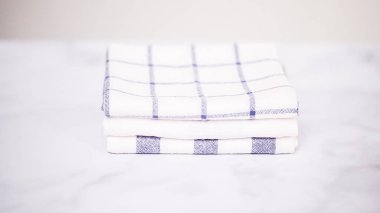 Mermer yüzey üzerinde mavi ve beyaz desenli kağıt havlu katlama.