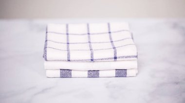 Mermer yüzey üzerinde mavi ve beyaz desenli kağıt havlu katlama.