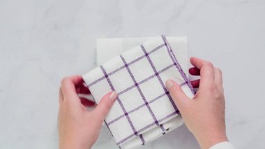 Mermer yüzey üzerinde mavi ve beyaz desenli kağıt havlu katlama.