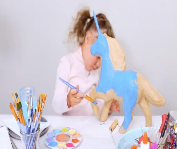 循序渐进 小女孩画纸纸浆独角兽与蓝色油漆 — 图库视频影像