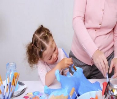 Adım adım. Anne ve kızı boyama kağıt mache unicorn mavi ile birlikte boya