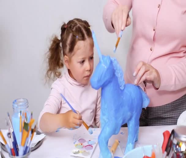 循序渐进 母亲和女儿画纸纸浆独角兽与蓝色油漆一起 — 图库视频影像