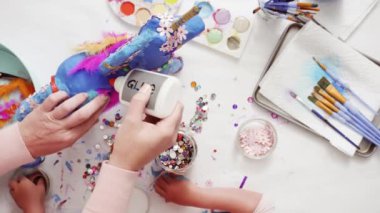 Adım adım. Anne ve kızı dekorasyon kağıt mache tek boynuzlu at birlikte