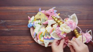 Pembe plaka üzerine Kraliyet krema şeker kurabiye şeklinde unicorn süslenmiş.