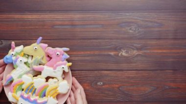 Pembe plaka üzerine Kraliyet krema şeker kurabiye şeklinde unicorn süslenmiş.