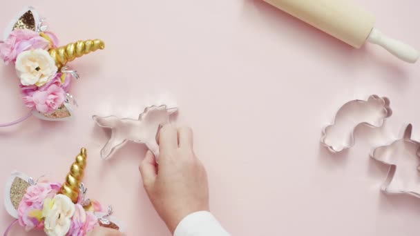ピンク板に高貴なアイシングで飾られたユニコーン シュガー クッキーの形 — ストック動画