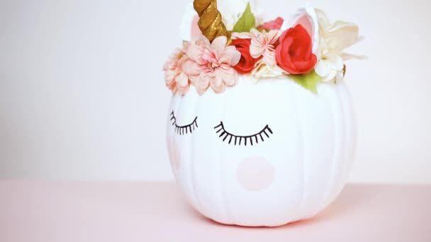 クラフトかぼちゃ塗られる白とピンクの背景にユニコーンとしてピンクの花で飾られました — ストック動画
