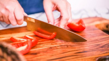 Adım adım. Ağaç kesme tahtası Dilimleme kırmızı dolmalık biber.