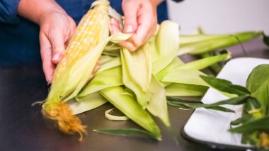Step by step. Shucking fresh organic corn to make mexican corn salad. clipart