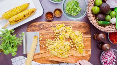 Adım adım. Izgara mısır koçanı ona ahşap kesme tahtası kesme.