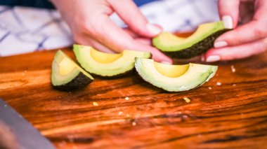Adım adım. Ağaç kesme tahtası Dilimleme taze avokado.