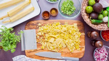 Adım adım. Izgara mısır koçanı ona ahşap kesme tahtası kesme.