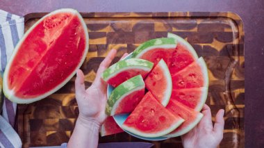 Ahşap kesme tahtası üzerinde kırmızı karpuz Dilimleme. 