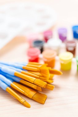 Yeni boya fırçaları ahşap bir masa üzerinde boya ile çeşitli.