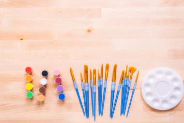 Ahşap bir masaya yeni boya malzemeleri.