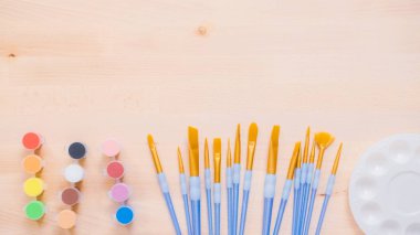 Yeni boya fırçaları ahşap bir masa üzerinde boya ile çeşitli.