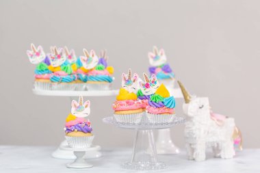 Tek boynuzlu at kek kek standları üzerine çok renkli buttercream krema ile.