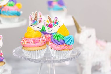 Tek boynuzlu at kek kek standları üzerine çok renkli buttercream krema ile.