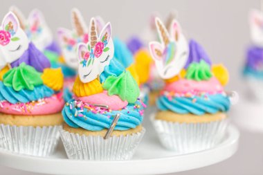 Tek boynuzlu at kek kek standları üzerine çok renkli buttercream krema ile.