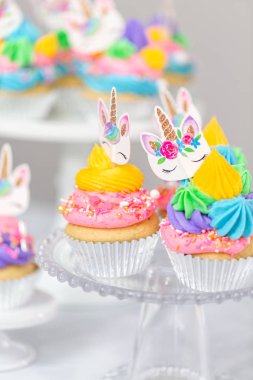 Tek boynuzlu at kek kek standları üzerine çok renkli buttercream krema ile.