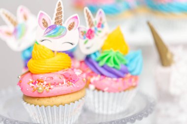 Tek boynuzlu at kek kek standları üzerine çok renkli buttercream krema ile.