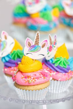 Tek boynuzlu at kek kek standları üzerine çok renkli buttercream krema ile.